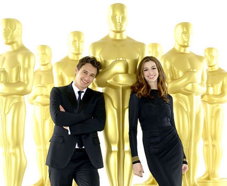 James Franco and Anne Hathaway posing in front of giant replicas of Oscar statuette