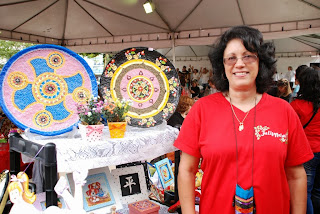 Iara Hesse com pintura em pratos de papier mâché (técnica a base de cola, água e jornal)