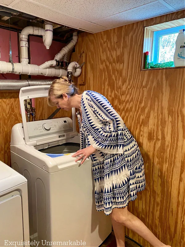 Woman adding top loading washing machine