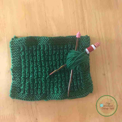 Picture of a knitted hurdle stitch blanket square with a garter stitch border