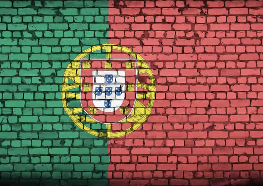 Imagem mostra um muro pintado com a bandeira de portugal.