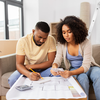 Homeowners reviewing blueprint and looking at money