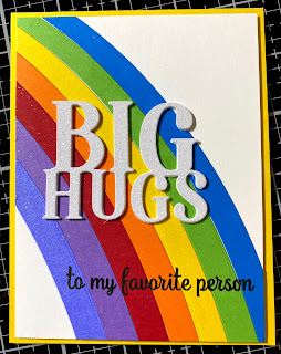 Card with a die cut rainbow, topped with a white giltter cardstock "Big Hugs" sentiment and "for my favorite person" stamped below.