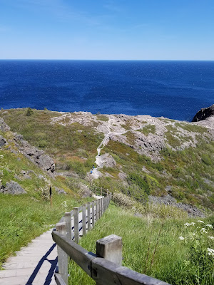 Long staircase leading down rocky hillside to Atlantic Ocean.