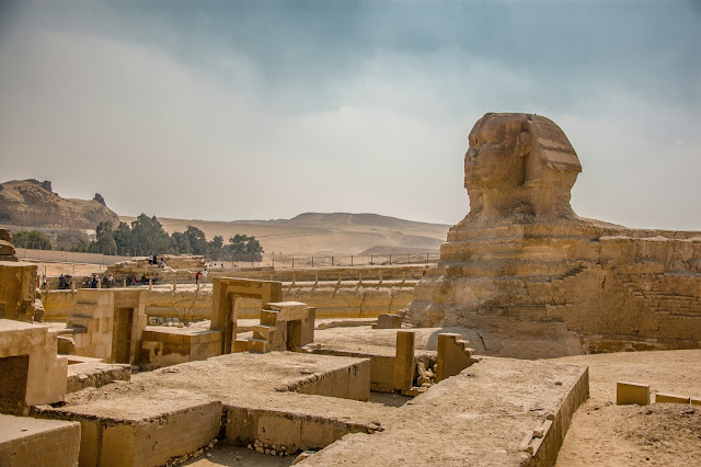 An image of the Sphinx of Giza, with the vast desert expanse in the background, under a hazy sky. This symbolizes the role of aerial LiDAR in archaeology, as it can scan such large historic sites from above, uncovering hidden structures and details of ancient civilizations. LiDAR technology enables archaeologists to detect and map out concealed features like burial sites and old roadways without disturbing the ground, paving the way for more effective and non-intrusive exploration and planning in the field of archaeology.