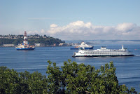 Ships bringing oil drilling equipment to Alaska, left, pass through Seattle's Elliott Bay on Wednesday, June 27, 2012, as a Washington State Ferry passes on its way into Seattle. Arctic drilling has been a contentious issue for environmentalists. (Credit: AP Photo/Donna Gordon Blankinship) Click to Enlarge.