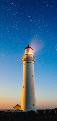 Lighthouse Wallpaper HD - A beautiful lighthouse in front of a blue sky at dusk.