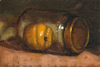 Oil painting of a lemon in a glass jar--laid on its side--with a gold-coloured lid.