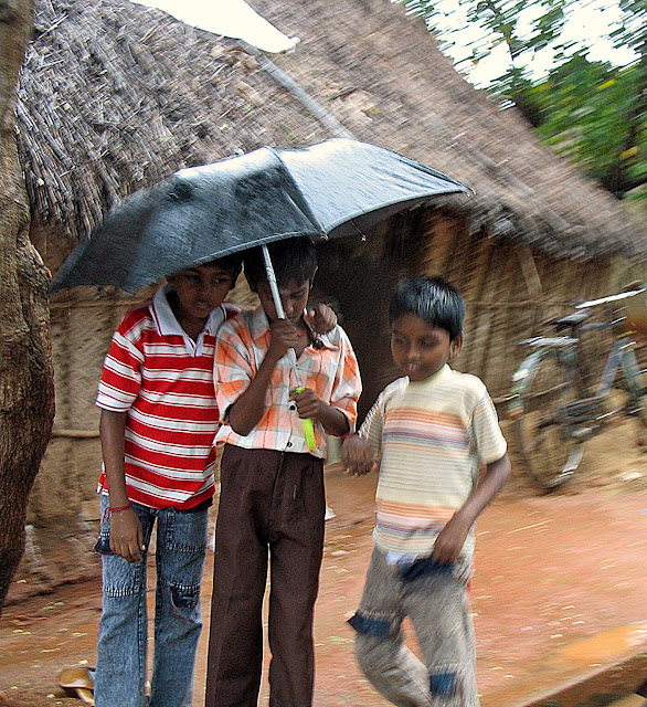 kids sharing an umbrella