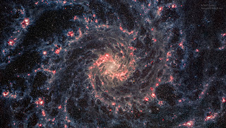 Spiral galaxy Messier 74 (also known as NGC 628) lies some 32 million light-years away toward the constellation Pisces. An island universe of about 100 billion stars with two prominent spiral arms, M74 has long been admired by astronomers as a perfect example of a grand-design spiral galaxy. M74's central region is brought into a stunning, sharp focus in this recently processed image using publicly available data from the James Webb Space Telescope. The colorized combination of image data sets is from two of Webb's instruments NIRcam and MIRI, operating at near- and mid-infrared wavelengths. It reveals cooler stars and dusty structures in the grand-design spiral galaxy only hinted at in previous space-based views.