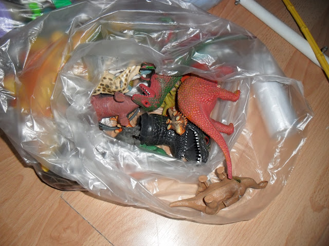 The last bag contains only plastic dinosaurs and other animals.