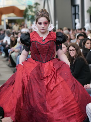 Woman wearing bright red puffy dress that looks like the red queen from Alice in Wonderland