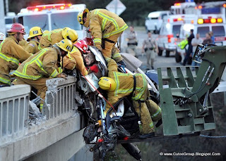 Firefighters rescue a family from a car dangling over a bridge after a fiery crash on Highway 101, California, US.