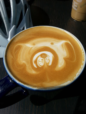 Image of cup of coffee with a foam design of a dog