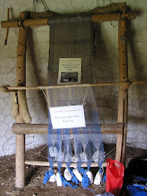 Ancient design of loom with warp threads held down by clay weights