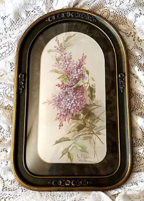 C Klein lilacs in a fancy antique barbola convex glass frame