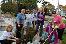 members of the Franklin Garden Club fall cleaning on the flowers around the monuments