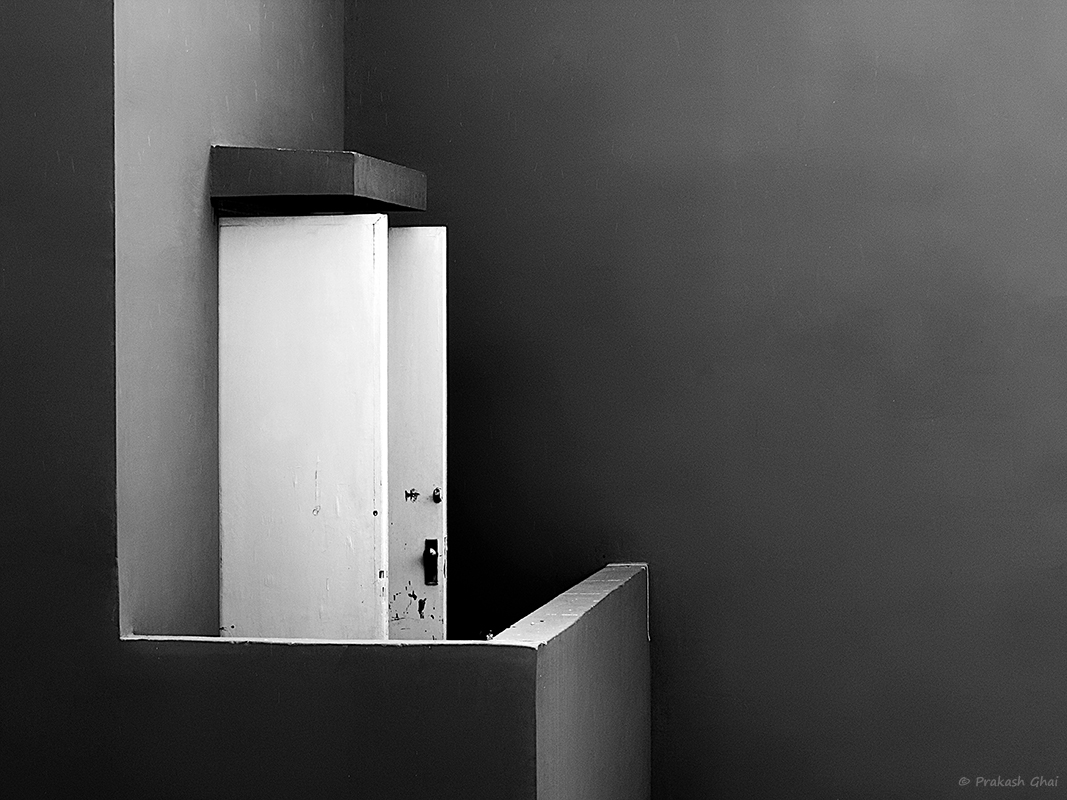 A Black and White Minimalist Photo of the open white door in the balcony, at Jawahar Kala Kendra Jaipur.