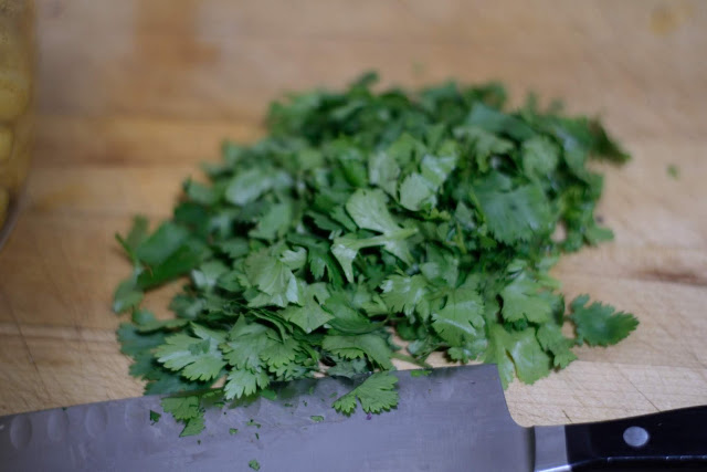 Chopped cilantro on the counter with a knife.