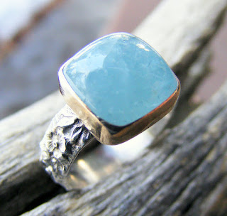 aquamarine gemstone in a gold bezel ring
