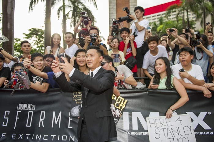 Han Geng poses with fans at the worldwide premiere screening of "Transformers: Age of Extinction"at the  on June 19, 2014 in Hong Kong, Hong Kong.