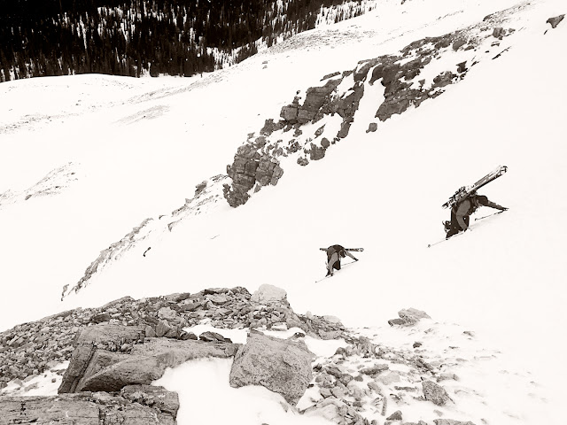 Two skiers bootpack up a couloir, Stanley Mitchell Hut.