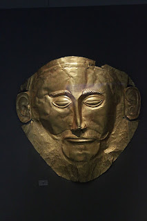 The so-called 'Mask of Agamemnon', a gold funerary mask from Mycenae, c. 1550-1500 BCE, now in the National Archaeological Museum, Athens. It depicts a flattened bearded male face, with his eyes closed.