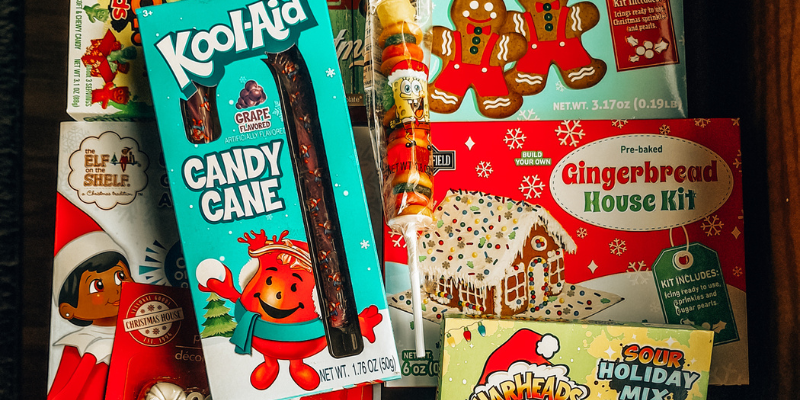 Assortment of festive gifts from Dollar Tree for the '12 Days of Christmas' tradition, including coloring books, candy, and gingerbread kits. | on the creek blog // www.onthecreekblog.com