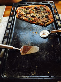 Half eaten tray of moose salami and vegetable pizza