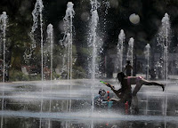 People cool off in a fountain in Nice as a heatwave hits much of the country (Credit: Reuters/Eric Gaillard) Click to Enlarge.