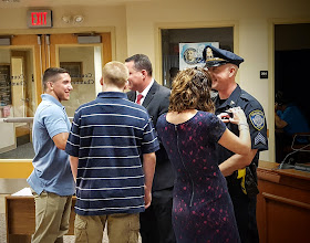 Detective MacLain and Sargent Zimmerman getting their new badges pinned by family members