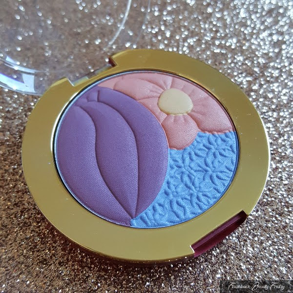 close up of open eyeshadow compact with embossed floral design in various colours