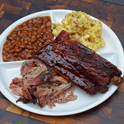 BBQ plate of smoked pork, spare ribs, beans and potato salad