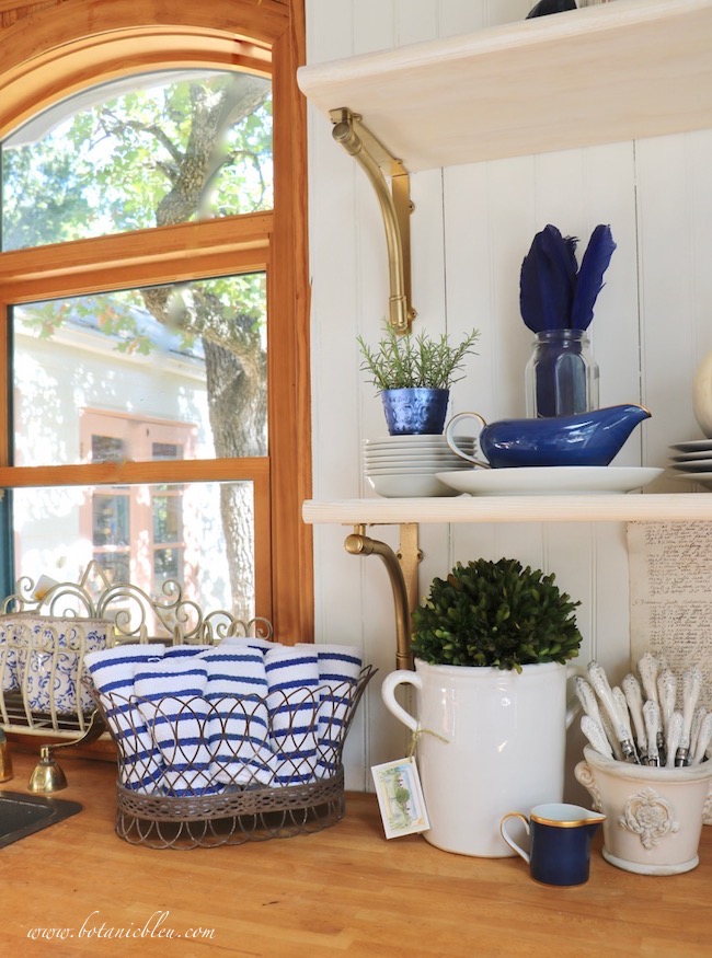 French Country style for fall decor includes a French wire basket, short flower pot with French medallion, and antique French script ledger