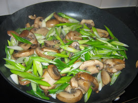 Mushrooms and spring onions being fried