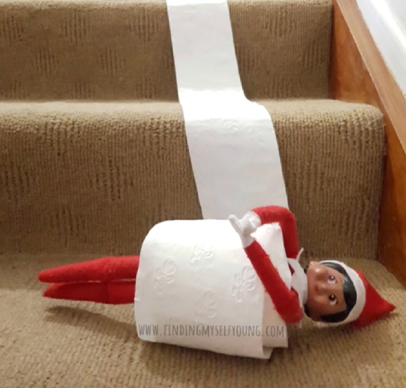 elf in toilet paper roll on stairs