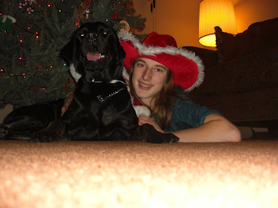 Picture of Rudy & I laying in front of the Christmas tree - both of us are wearing Santa hats