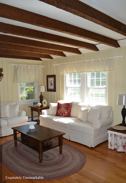 Ivory living room decor with red pillow on sofa