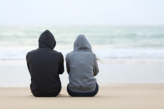 Two People Sitting by the Beach