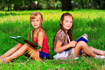 Niñas leyendo sus libros en el parque