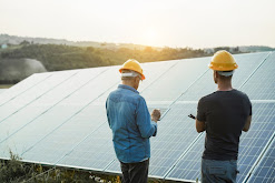 Workers stand near solar panels