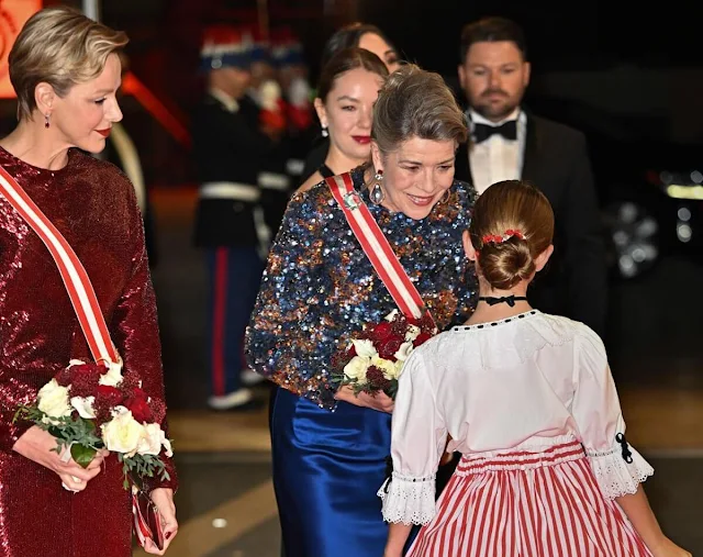 Princess Charlene wore a sequins stretch sheath long gown by Akris. Princess Caroline wore a blue skirt and sequin top by Chanel