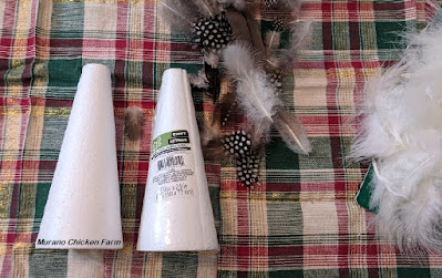 Craft supplies for feather tree. Foam tree forms and a pile of feathers.