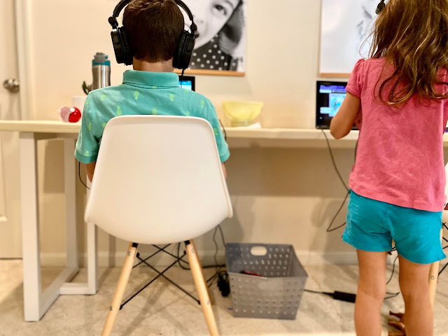 Little boy sitting at a chair at his DIY desk