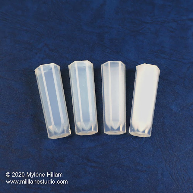 4 slender crystal moulds showing signs of turning from clear to white as they age