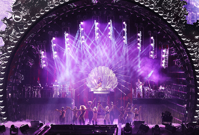 A shot of Beyoncé performing on the Renaissance World Tour. Beyoncé is performing “Virgo’s Groove” whilst sat inside a giant silver clamshell.