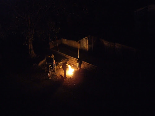 Trash fires provide warmth for rickshaw drivers and curs.