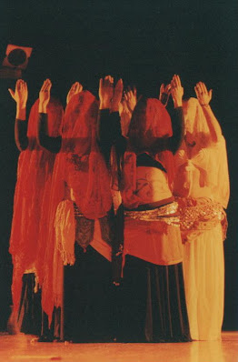 Danza Orientale Contemporanea "ARDVI SURA ANAHITA"  TEATRO TENDA PIANETA, 2003   Danza Dea Madre Nell'ambito di "Sura, o dell'ebbrezza divina". Lo spettacolo "Ardvi Sura Anahita" nasce come prosecuzione del primo "Devi - Inno alla Dea Madre", ambedue prodotti per "Off Broadway " 2003 e 2004 (Mediascena Europa), riprendendone e sviluppandone alcuni spunti particolari inerenti all' indagine sulla spiritualità femminile concepita in modo istintivo, corporeo e primordiale.  Prende quindi il titolo dal nome dell'antica divinità persiana (i cui attributi erano infatti "umida, fertile e feconda") che presiedeva alle acque, Dea celeste fonte di tutte le acque terrestri, elemento che domina sovrano nelle danze mediorientali, caratterizzate da un moto fluido, ipnotico ed arcaico. Una Dea delle Acque quindi, per una danza anticamente legata ai culti della fecondità i cui moti circolari riportano ad un vissuto arcaico e non lineare del tempo. Lo spettacolo si sviluppa in una serie di quadri che alternano canti, danze e recitazione mirando a suggerire un panorama quasi onirico della spiritualità femminile: dal piacere corporeo di un gruppo di ragazze che giocano con le gonne, all'estasi liberatoria delle danza vorticose, al rapporto con quel "velo" che tutto copre. Viene quindi utilizzato un linguaggio sincretico che mira a rivalutare la bellezza di questa antica tecnica, liberandola da forme parodistiche pseudo-orientali, se non addirittura cabarettistiche, in cui la cultura attuale sembra relegarla. Non più "movenze femminili", ma la ricerca del movimento potente, che ridia alla donna la sensazione di un femminile totale, multiforme e spiritualizzato, aldilà del confine in cui ogni cultura ha sempre cercato di rinchiudere queste "acque mutevoli".  Coreografia e regia: Marialuisa Sales;  Interpreti:  Daniela Cipriani; Carlotta Facchini; Marialuisa Sales; Paola Stella;  Giovanna Leva Joglekar (per il brano di Fusion);  Attrici-Danzatrici:  Camilla Triolo; Giovanna Genovese;  Testi: liriche dei poeti classici Rumi, Jami;  Decorazioni: Paola D'Alberti Repliche per  "Terzo Festival di Danza Multietnica" di Roma (2004);  "San Lorenzo, Arte in Movimento" (2004) (CLICCARE SULLA PRIMA FOTO PER APRIRE LA VISUALIZZAZIONE)