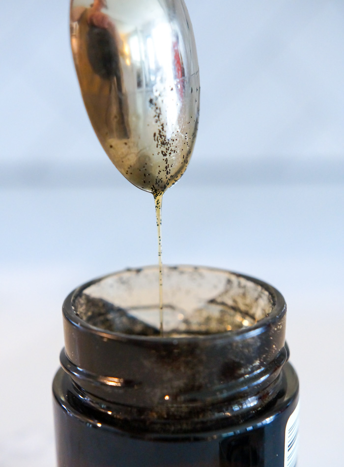 Trader Joe's Bourbon Vanilla Bean Paste dripping off spoon into jar