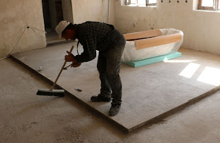 Bekir tidying up before starting to lay tiles